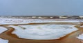 Wide flood of peat water flowing to the winter lake