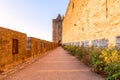 Wide fortified walls with walkways and arches of medieval castle of Carcassonne town at sunset Royalty Free Stock Photo