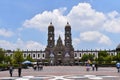 Wide front view of the Zapopan basilica, with some clouds in the sky