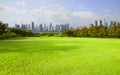 Wide green grass ground of public park against high building in Royalty Free Stock Photo