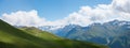 Wide green pasture with winding way, Gotschnagrat mountain top, view to swiss alps