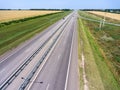 Wide highway with four lanes, aerial view at straight motorway in agricultural fields. Russia