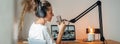 Wide image. Woman podcaster streaming and broadcasting her podcast from homemade studio