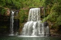 A wide jungle waterfall among the bright tropical plants