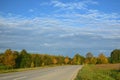 Wide landscape in Bavaria in autumn with harvested fields and trees against a blue sky with clouds