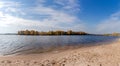 Wide navigable river with sandy shore against forested opposite bank