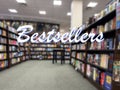 Wide out of focus view of the inside of a bookstore with the word Bestsellers in the foreground