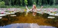 Wide panorama banner Portrait of sensual sexy young redhead woman mermaid sits sensitive seductive with pink water lilies in the