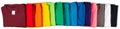 Wide panorama banner row of many fresh new fabric cotton t-shirts in colorful rainbow colors isolated. Pile of various colored