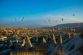 Wide panorama of Cappadocia landscape - colored balloons flying over mountain peaks and fantastic valley. Air balloons above