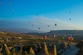 Wide panorama of Cappadocia landscape - colored balloons flying over mountain peaks and fantastic valley. Air balloons above
