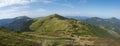 Wide panorama of grassy green hills and slopes at ridge of Low Tatras mountains with hiking trail footpath, mountain Royalty Free Stock Photo