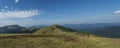 Wide panorama of grassy green hills and slopes at ridge of Low Tatras mountains with hiking trail footpath, mountain Royalty Free Stock Photo