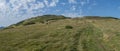 Wide panorama of grassy green hills and slopes at ridge of Low Tatras mountains with hiking trail footpath, mountain Royalty Free Stock Photo