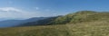 Wide panorama of grassy green hills and slopes at ridge of Low Tatras mountains with hiking trail footpath, mountain Royalty Free Stock Photo