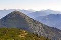 Wide panorama of green mountain hills in sunny clear weather. Carpathian mountains landscape in summer. View of rocky peaks covere Royalty Free Stock Photo