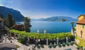 Wide panorama of Lake Como and the Alps from the green garden of Hotel Royal Victoria in Varenna, Italy. Royalty Free Stock Photo