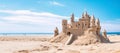 A wide panoramic shot of an elaborate sandcastle on a sandy beach with turrets, wall and a flag Royalty Free Stock Photo