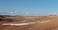 Wide panoramic view of bright autumn mountain steppe landscape. Awesome alpine view from pass to mountain valley in sunlight and