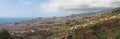 wide panoramic view of funchal in madeira showing the city surrounded by hills and mountains with forests and motorway bridge in