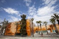 Wide panoramic view, orange building and palm trees. Blue sky with clouds Royalty Free Stock Photo