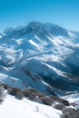 Wide panoramic view of a snow-covered mountain range with clear skies and deep valleys. Royalty Free Stock Photo