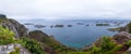 Wide panoramic view from top of cliff on the ocean and on blue panorama of mountains and Reine in Lofoten islands, Norway Royalty Free Stock Photo