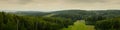 wide panoramic view from the top of a high hill to the mountainous wooded area of the ski resort in the summer Royalty Free Stock Photo