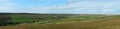 Wide panoramic view of yorkshire dales landscape with fields and farmhouses enclosed by stone walls with open moorland above Royalty Free Stock Photo