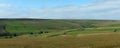 Wide panoramic view of yorkshire dales landscape with fields and farmhouses enclosed by stone walls with open moorland above Royalty Free Stock Photo