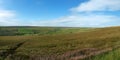 Wide panoramic view of yorkshire dales landscape with fields and farmhouses enclosed by stone walls with open moorland above Royalty Free Stock Photo