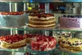 A wide range of cakes with berries and nuts in the pastry shop