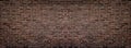 Wide red shabby brick wall texture. Masonry panorama. Dark rough brickwork panoramic background Royalty Free Stock Photo