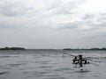 The wide river on a gray cloudy day. Cozy bridge for fishing. Silver waves on dark water