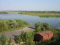 A wide river in the late sunny summer morning. There`s an old bridge in the river