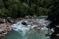 Wide river among mountains of gorge and green vegetation around. Stormy mountain river with bluish tinge from sky flows quickly Royalty Free Stock Photo