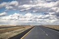 Wide road resting on the horizon with fields with neatly cut grass beckons forward tourists and travelers exploring new places and Royalty Free Stock Photo