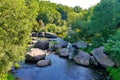 Wide rocky river surrounded by beautiful tall trees