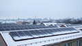 Wide rooftop solar array over snowy residential district Royalty Free Stock Photo