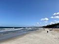 wide sandy beach blue sky with clouds visible waves over the baltic sea