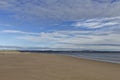 The wide sandy deserted beach of Tentsmuir Point on the southern edge of the Tay Estuary, with gentle waves breaking on the sand. Royalty Free Stock Photo