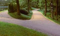 Wide sandy paths in the park, bordered with stone drainage grooves, diverge in different directions Royalty Free Stock Photo