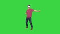 Advanced gamer in casual outfit playing dancing game in VG headset on a Green Screen, Chroma Key.