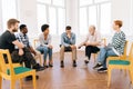 Wide shot of bearded aged professional male mentor leader counselor coach speaking at diverse business meeting with team Royalty Free Stock Photo