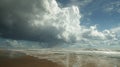 Heavy storm clouds loom over a wide beach. Royalty Free Stock Photo