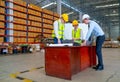 Wide shot of Caucasian warehouse worker team discuss about the project using paper and laptop to support the explaination of their Royalty Free Stock Photo