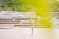 Wide shot of Caucasian young woman practicing yoga performing namaste pose with closed eyes standing on fit mat in city Royalty Free Stock Photo