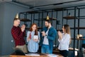 Wide shot of cheerful redhead young woman opening present given by colleagues in office. Royalty Free Stock Photo