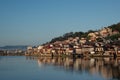 Wide shot of a city full of houses on a hill by the shore on a cool day