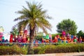 wide shot of colorful raavan effigies placed on the side of the road street with plants in between ready to be sold